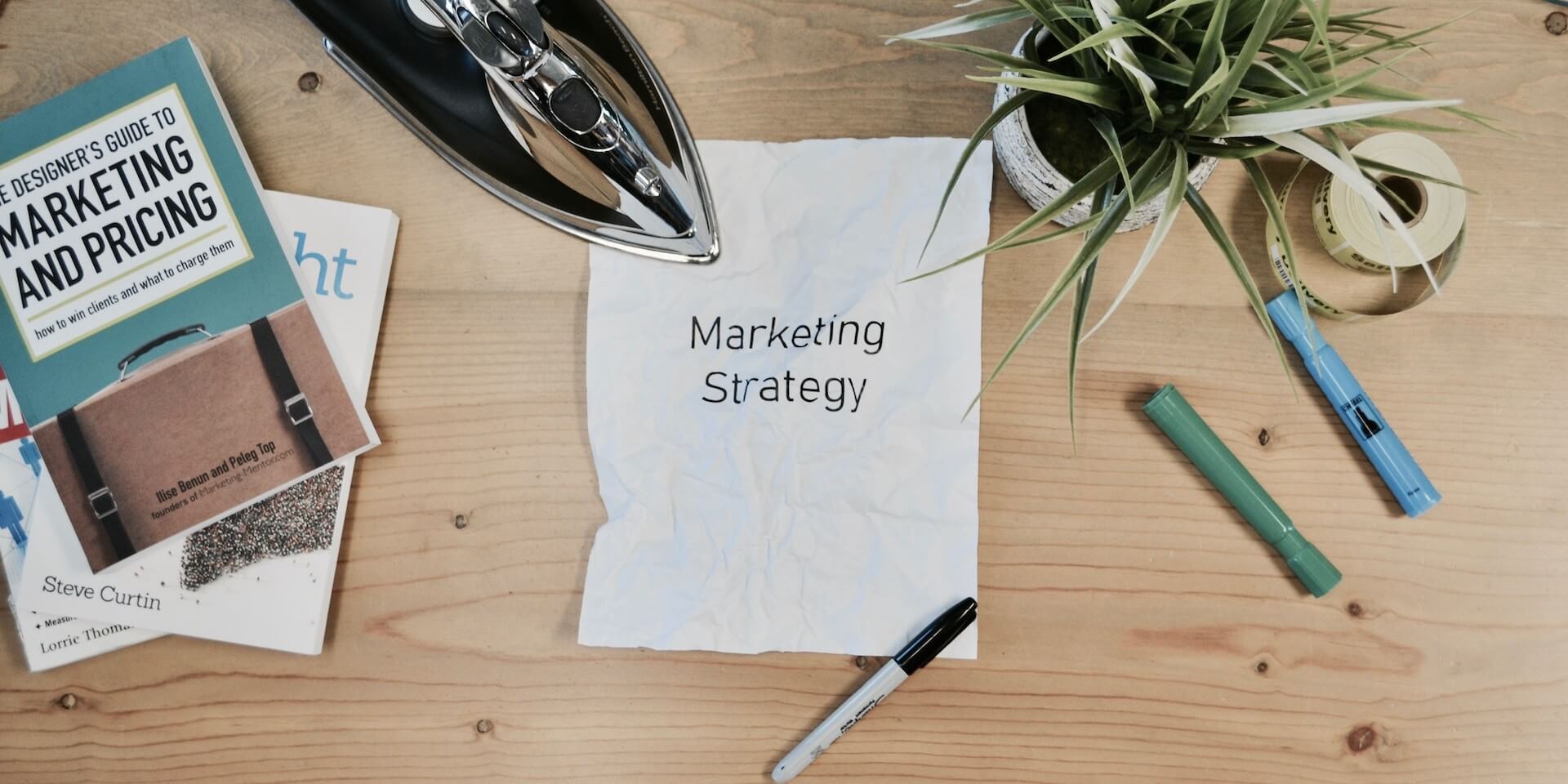 looking down on a crumpled piece of paper with "marketing strategy" written on it